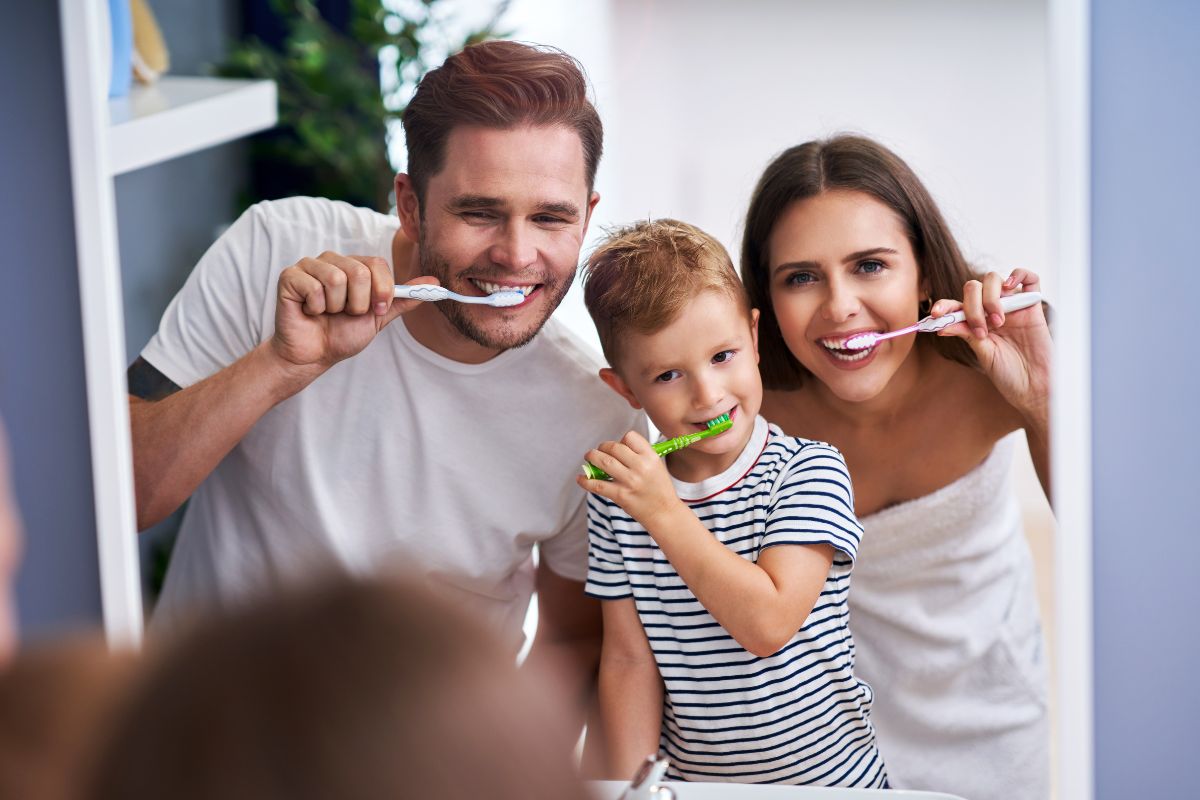 Family brushing teeth together in the bathroom.